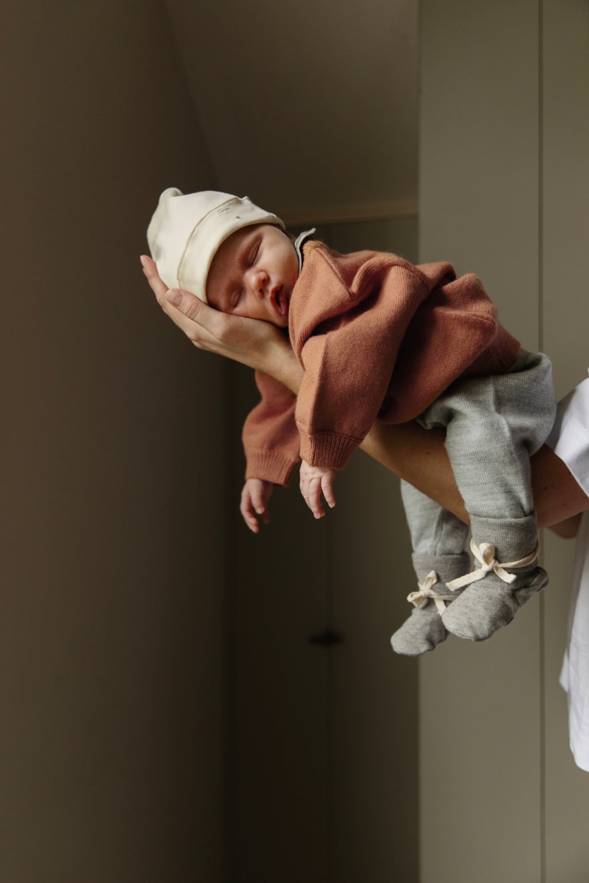 Baby sleeping in adults hands