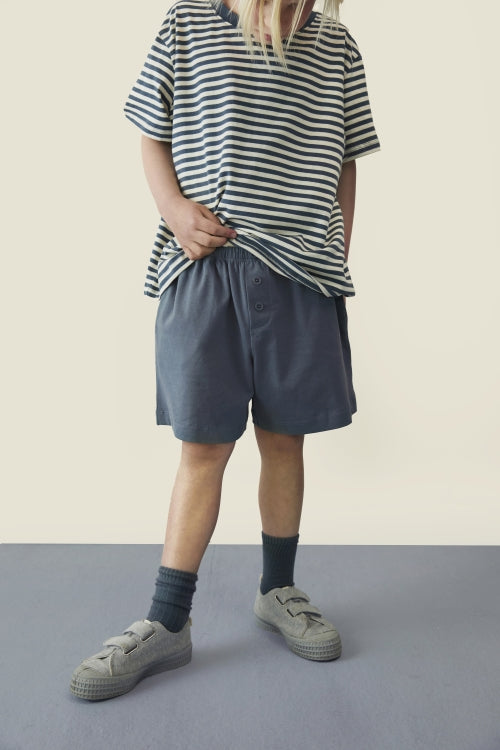 Child wearing Gray label shorts and oversized striped top