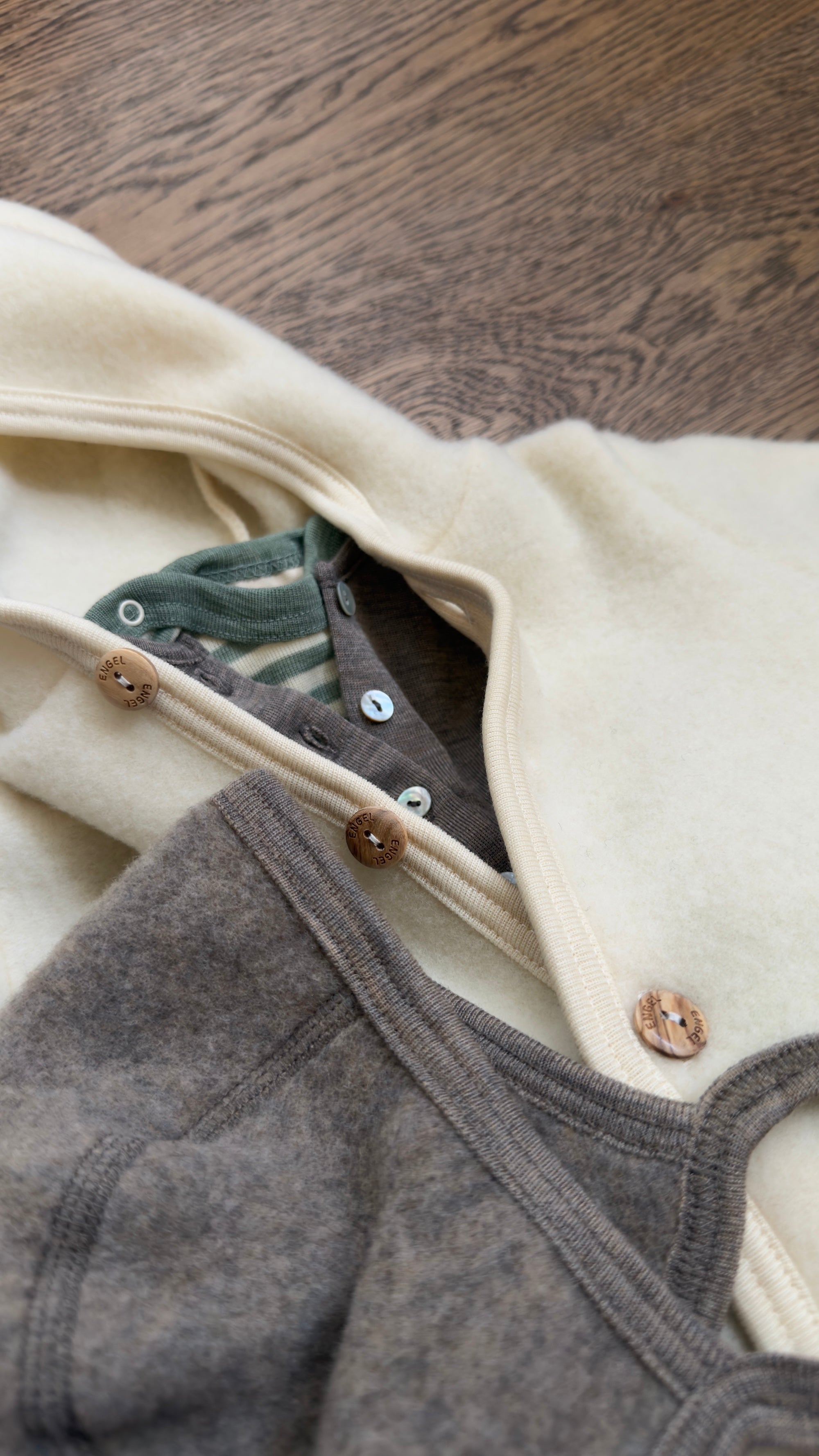 Engel Natur Overall in Natural, with layers of clothing underneath. 