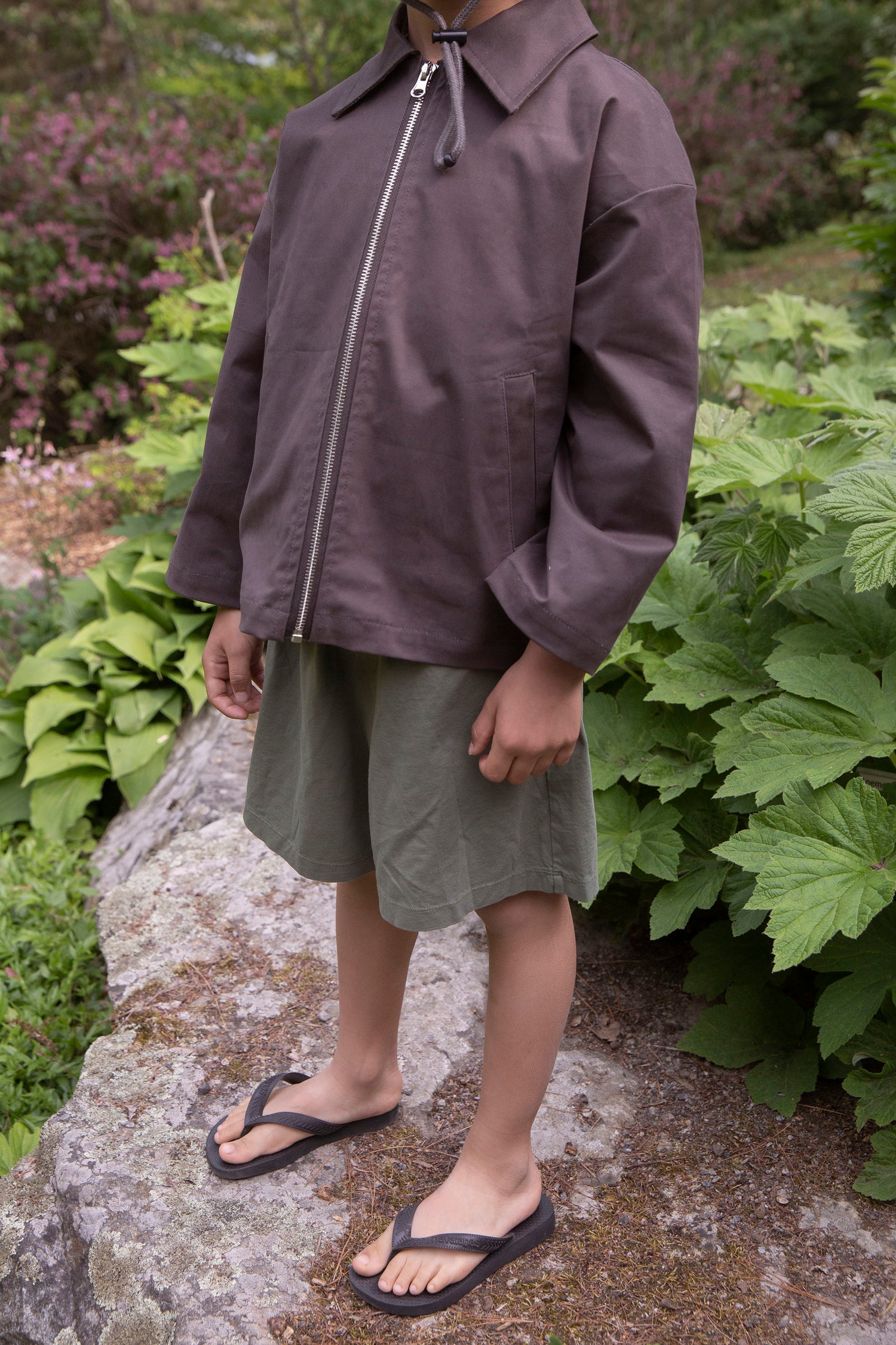 Child wearing Façade Mido Runner Shorts in green, organic cotton kids shorts styled outdoors