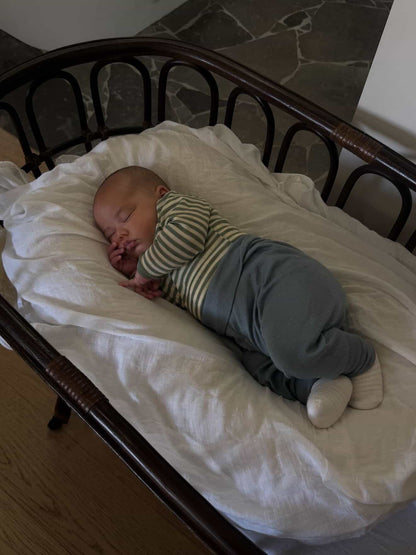 Sleeping baby wearing Engel Natur Wool Silk baby pants in mountain blue and merino wool bodysuit in sage natural