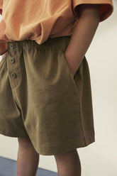 Detail of decorative button on organic cotton jersey shorts