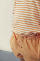 Detail of decorative button on organic cotton jersey shorts