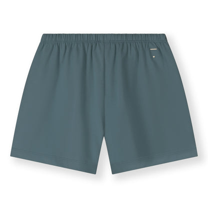 Organic cotton jersey shorts made from GOTS-certified cotton, shown in blue grey colour. Showing logo on the back side. 