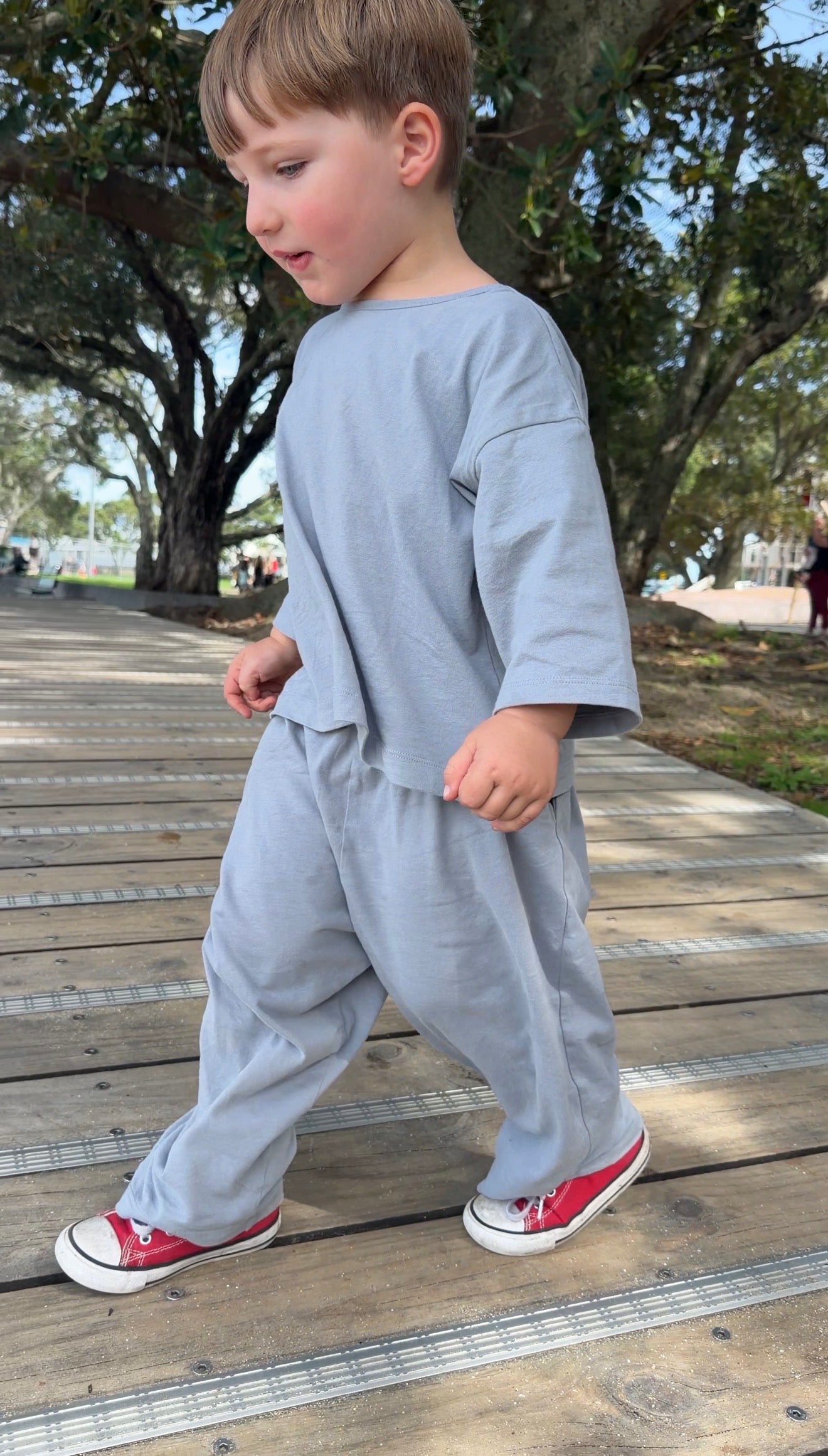 Child wearing Gray Label organic cotton pull up pants and dropped shoulder tee in stone grey