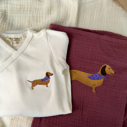Close up of sausage dog embroidery on organic wrap bodysuit