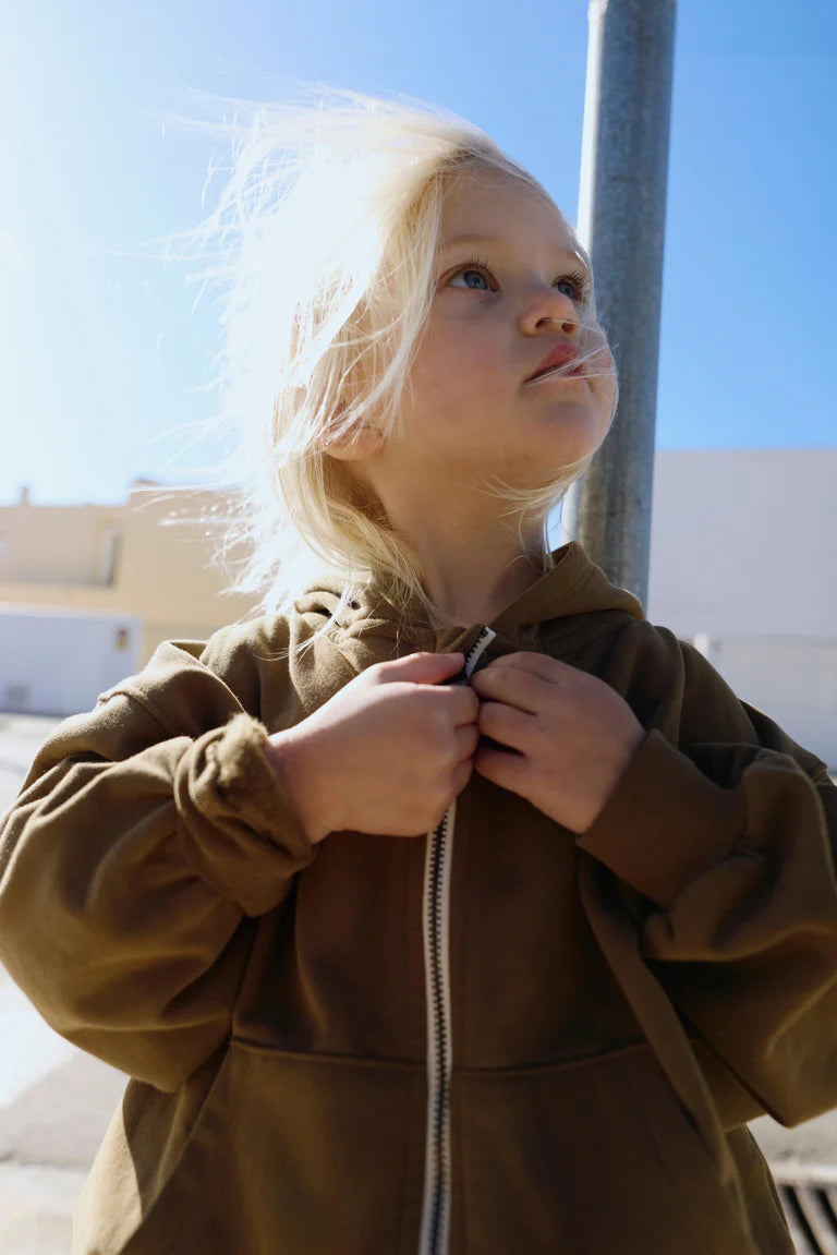 Child wearing Gray Label Zip Cardigan, standing outdoors on a sunny day.