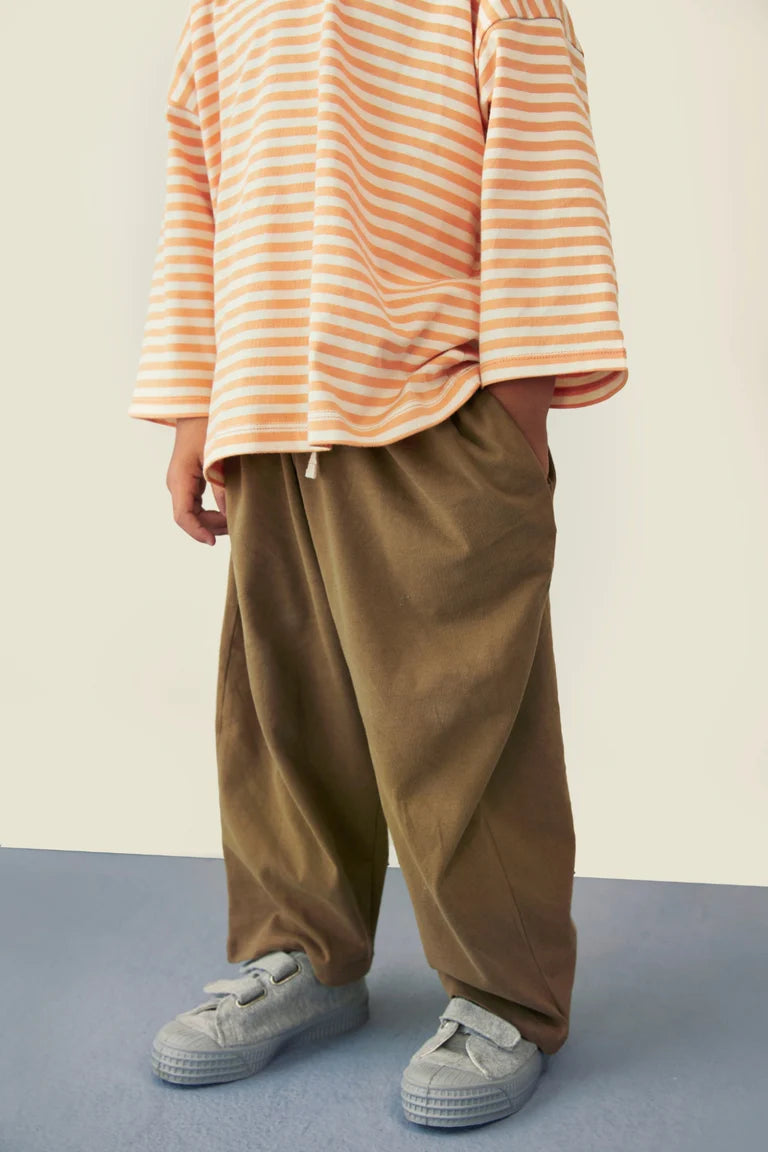 Child wearing Gray Label organic cotton pull up pants and dropped shoulder tee in woody