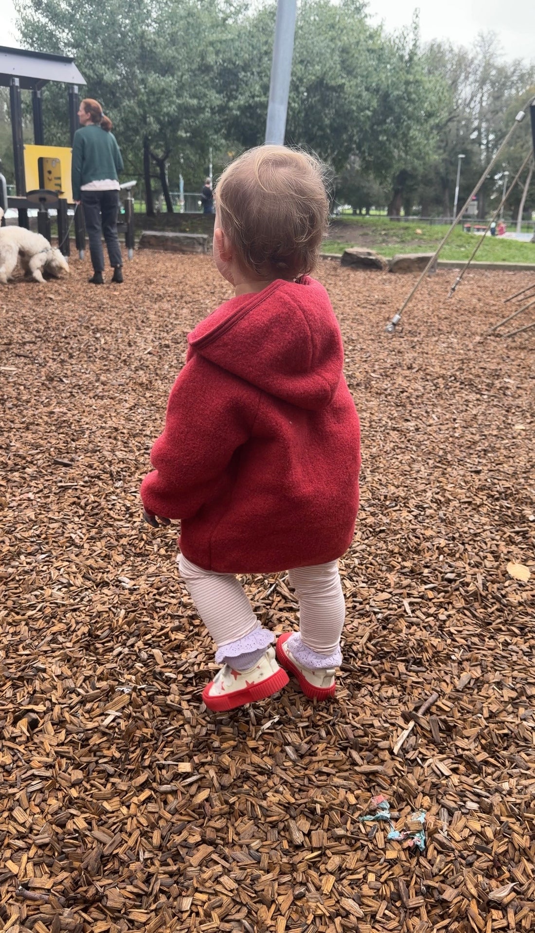Child in playground wearing Gray Label Leggings in color faded pink and Red jacket