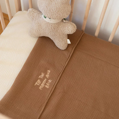 Handmade chunky muslin baby blanket in warm brown nursery