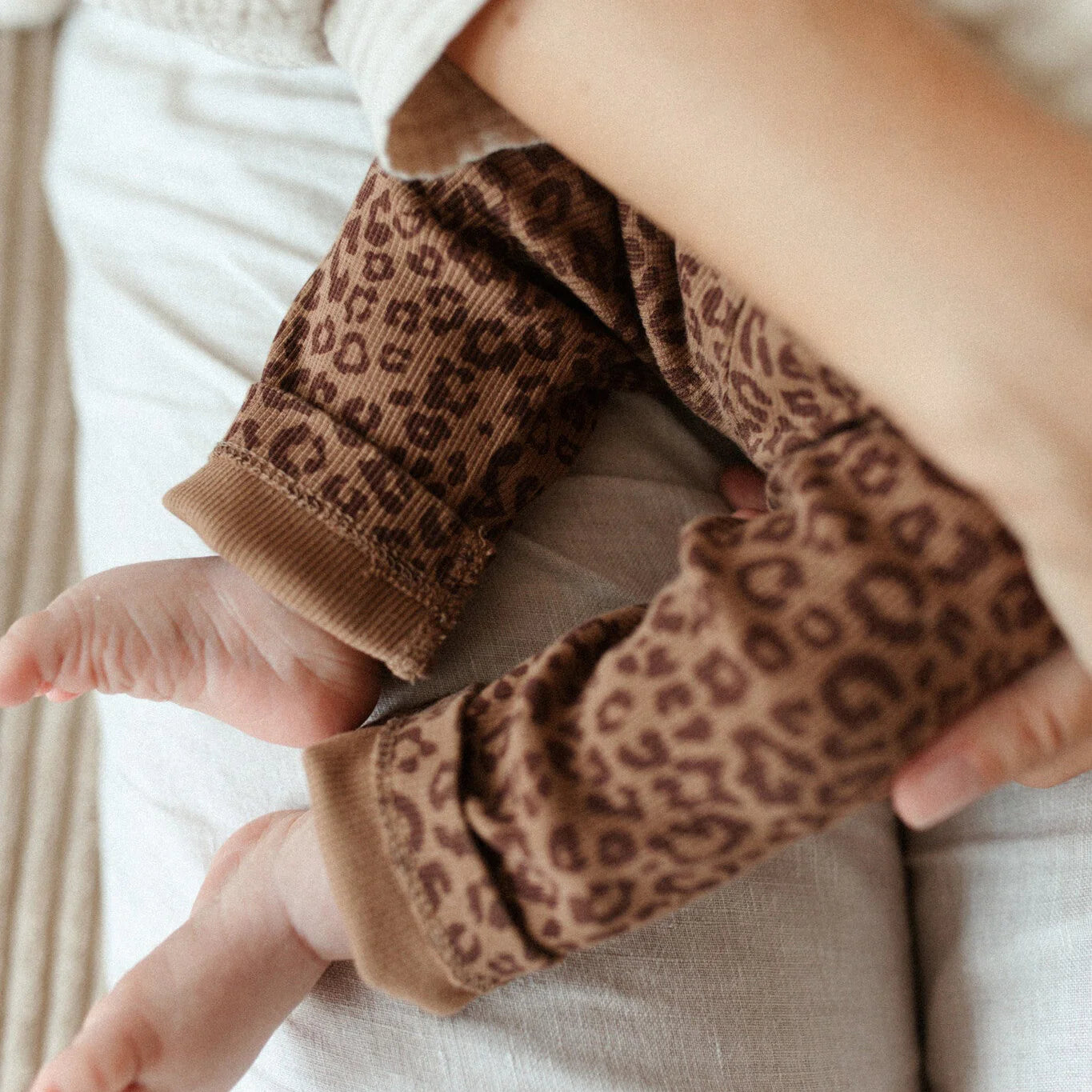 Close up of leopard print baby pants made from GOTS organic cotton