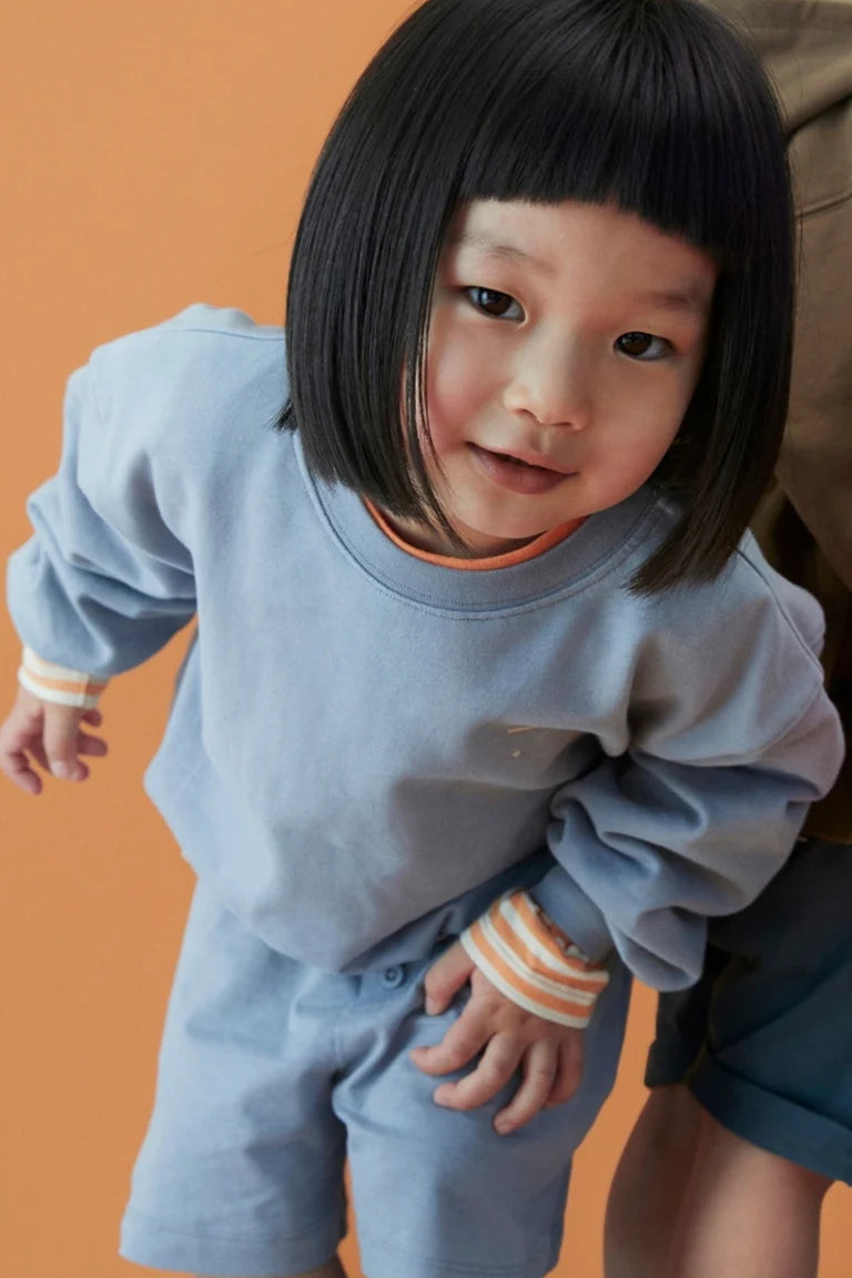 Child wearing Gray Label organic cotton fleece sweater in stone grey