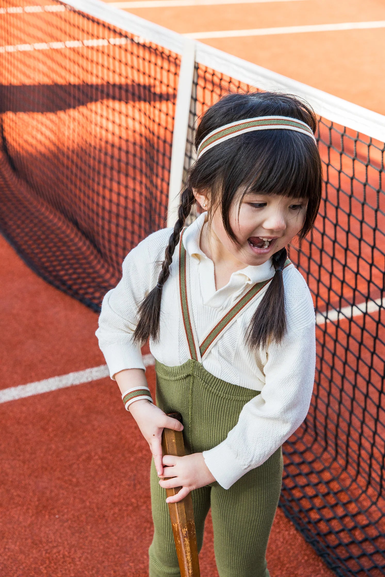 Child wearing Silly Silas footless tights with braces in Olive Stripe outdoors